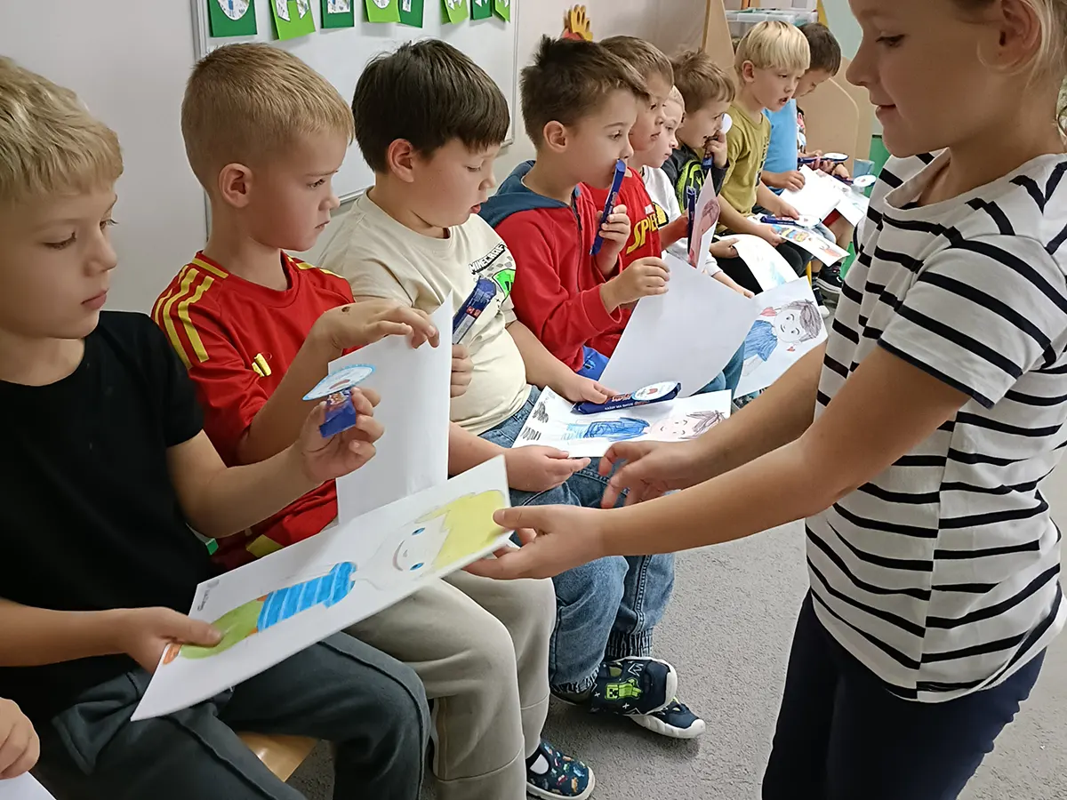  Dzieci siedzą na krzesłac...