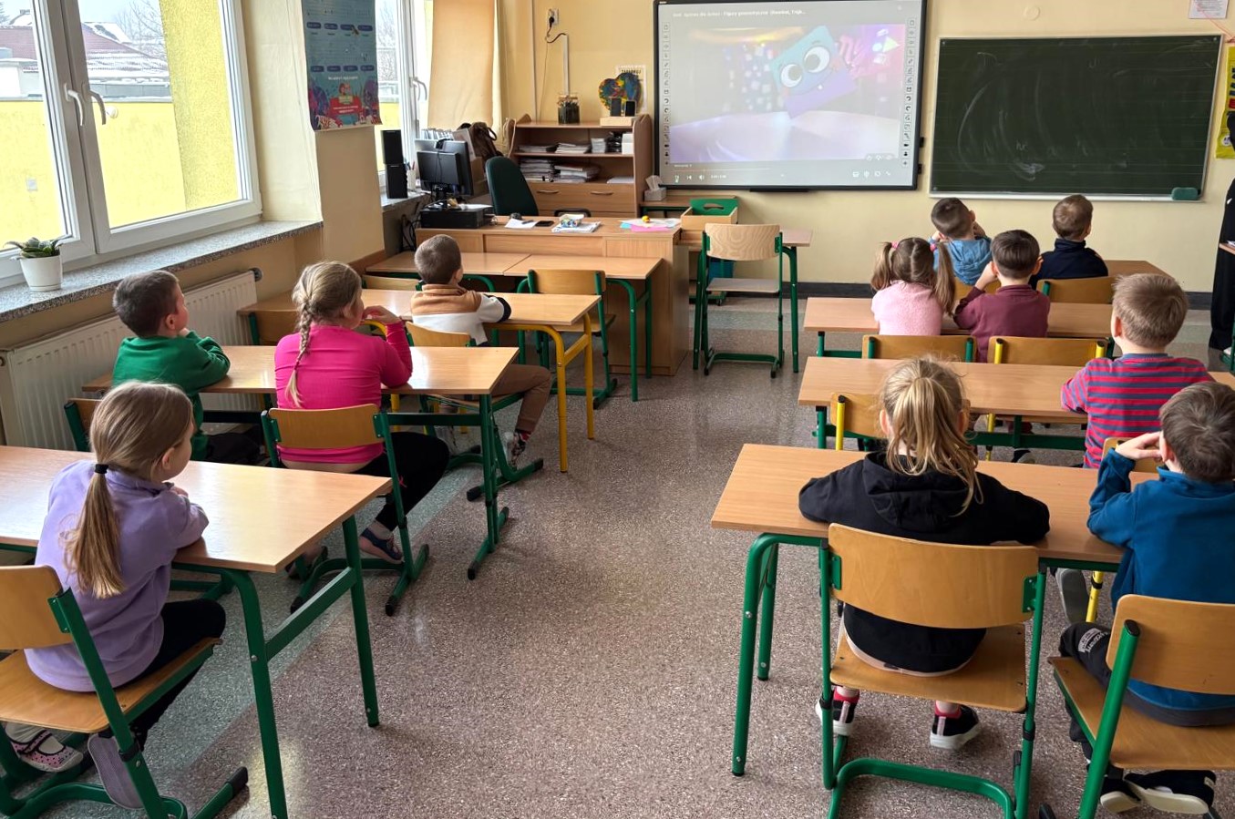  Dzieci siedzą w ławkach