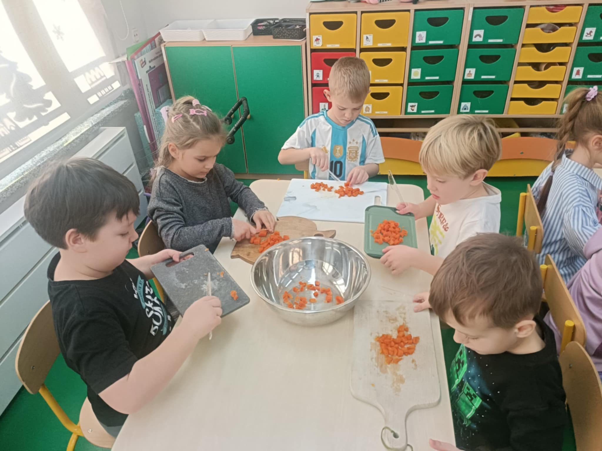  Dzieci siedzą przy stole,...